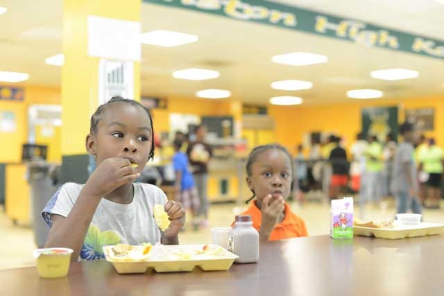 Celeste and Elijah Hawley eat lunch at the Lenoir County Schools Summer Food Service Program held at Kinston High School on Wednesday.