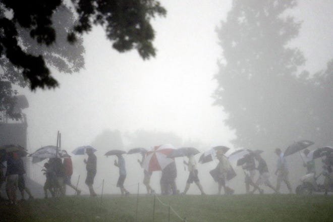 Fan leave the course during the third rain delay in the first round of the U.S. Open at Oakmont Country Club on Thursday.