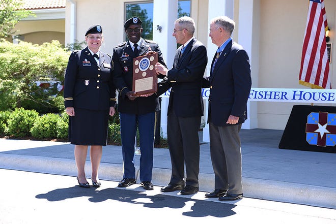 Photo by Sameria Zavala/WAMC PAO (Left to right) Col. Suzanne Scott, deputy commander for nursing and patient services, Womack Army Medical Center, Command Sgt. Maj. Fergus Joseph, Col. (retired) Walter Marm and Col. (retired) Gordon Roberts hold the plaque for the new Fisher House grand opening at Fort Bragg, June 9.