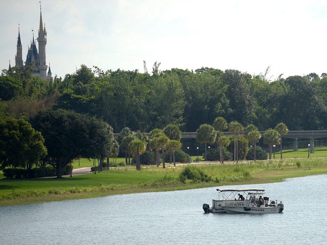 Orange County sheriff's officers search the Seven Seas Lagoon between Walt Disney World's Magic Kingdom theme park, left, and the Grand Floridian Resort & Spa on Wednesday in Lake Buena Vista after a 2-year-old boy was dragged into the lake by an alligator.