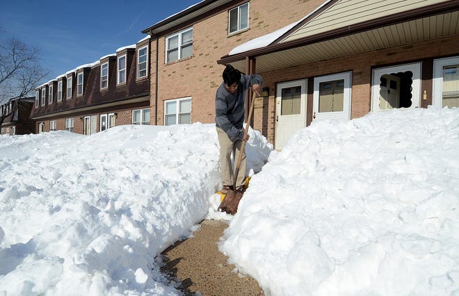 Jaweed Ahmed, of the Bienvenue Condominiums in Burlington Township, finishes shoveling his steps to get into his home on Monday, Jan. 25, 2016. Residents are upset that the condo association has not provided shoveling and snow clearing services, which they say they pay for.