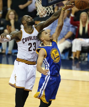 Cleveland Cavaliers forward LeBron James (23) blocks a shot by Golden State Warriors guard Stephen Curry (30) during the second half of Game 6 of the NBA Finals in Cleveland on Thursday. Game 7 is Sunday night. Photo by AP