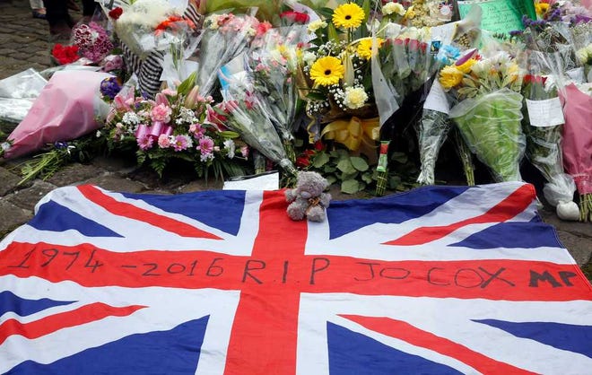 A Union flag is placed in front of floral tributes in Birstall, northern England, for Jo Cox, the 41-year-old British Member of Parliament shot to death in northern England, Friday June 17, 2016. The mother of two young children was shot to death Thursday afternoon in her constituency near Leeds. A 52-year-old man has been arrested but has not been charged. (Danny Lawson/PA via AP) UNITED KINGDOM OUT NO SALES NO ARCHIVE