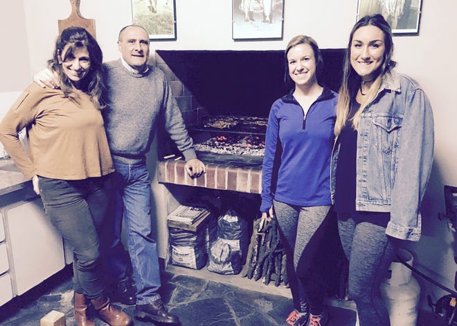 Maddie Breedlove, right, and her cousin Larissa Lempke, second from the right, are shown by the built-in grill in the kitchen of Juan and Maria Repetto in Magdalena, Argentina, during a recent visit. Breedlove and Lempke’s grandmother, Louise Tharp, of Kewanee, tossed a bottle in the Atlantic Ocean off the coast of Brazil while on vacation in 1993. Repetto found the bottle in a river near his home in Argentina a few months later and contacted Tharp. They have stayed in touch ever since. Since Louise could not make the trip for health reasons, her granddaughters decided to travel to Argentina and meet the man their grandmother met with a message in a bottle.