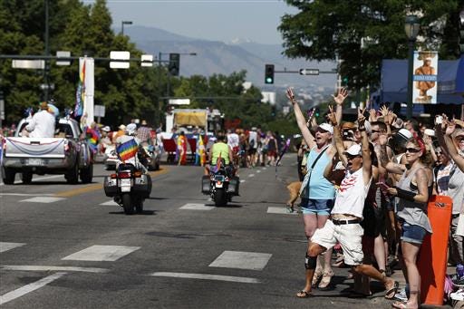 A crowd cheers for participants in the gay pride parade in Denver, Sunday June 19, 2016. (AP Photo/Brennan Linsley)