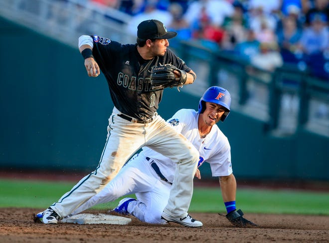 Coastal Carolina shortstop Michael Paez throws to first after forcing out Florida's Jonathan India to complete a double play during the second inning Sunday of the College World Series in Omaha, Neb. (Nati Harnik/The Associated Press)
