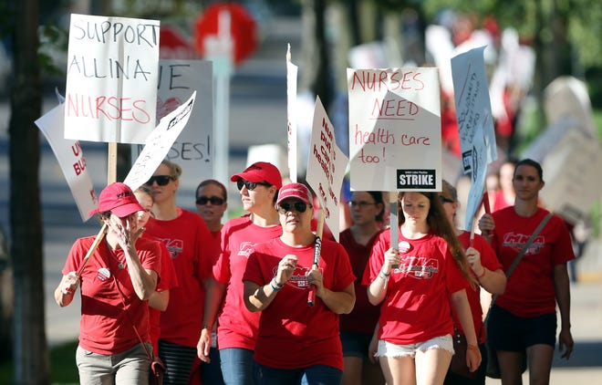 Thousands of nurses walk around Abbott Northwestern hospital on the first day of a strike Sunday in Minneapolis, Minn. About 4,800 nurses at five Minneapolis-area hospitals, all operated by Allina Health, began a weeklong strike Sunday over a contract impasse.