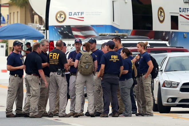 The FBI gather early Monday, June 20, 2016, in front of Pulse Nightclub at the mass shooting scene in Orlando. Federal investigators promised to provide more insight as to what was happening inside the Pulse nightclub after a gunman started a deadly assault that was the worst mass shooting in modern U.S. history. (Red Huber/Orlando Sentinel via AP)