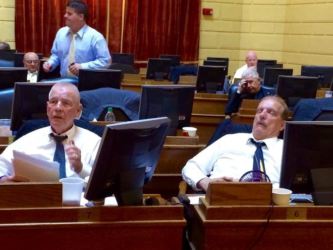 Rep. James McLaughlin, D-Cumberland, left, follows the action on the floor of the House at 5:10 a.m. Saturday while Rep. Robert Phillips, D-Woonsocket, dozes near the end of the Rhode Island General Assembly's marathon final day of the session. The Providence Journal/Alisha Pina