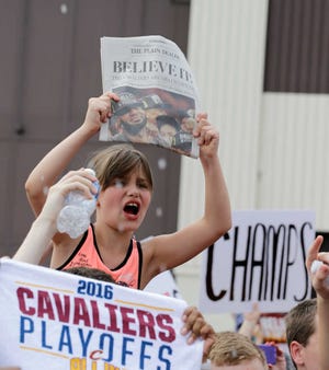 A Cleveland Cavaliers fan celebrates while waiting for the team to arrive in Cleveland, Monday, June 20, 2016. Lebron James came home with the trophy he promised, and the championship Cleveland has coveted for 52 years. The NBA superstar, born and raised in nearby Akron, stepped off a plane Monday and hoisted the shiny Larry O'Brien Trophy as more than 10,000 fans celebrated the city's first title since 1964. (AP Photo/Tony Dejak)