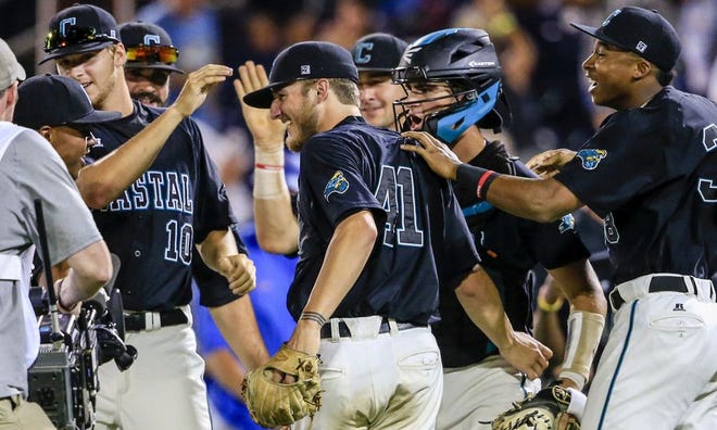 Coastal Carolina pitcher Andrew Beckwith (41), who pitched a complete game, is surrounded by celebrating teammates following an NCAA men’s College World Series baseball game against Florida in Omaha, Neb., Sunday. Coastal Carolina won 2-1.
