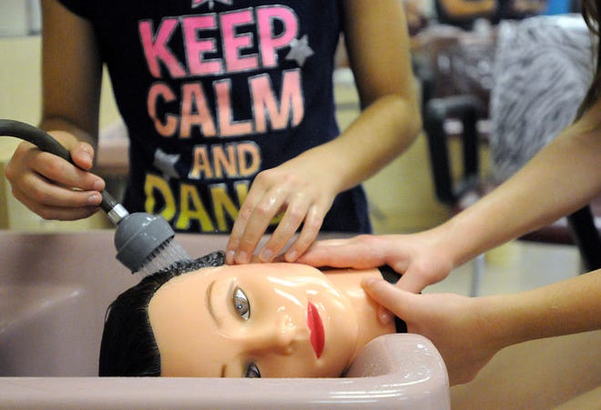FILE PHOTO Bucks County Technical High School will hold its annual summer exploratory program for fifth through eighth graders from the tech school's six sending districts between July 11 and July 28. Here in this photo from 2014, cosmetology students Angelina Gallagher and Jessica Swope wash a mannequin's hair, which is made from human hair.
