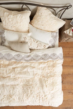 A ruched cotton voile and jersey flowers creates a soft, floaty duvet from Anthropologie. With long summer days and languid nights ahead, creating an ethereal, relaxing space is a fun idea. (Anthropologie via AP)