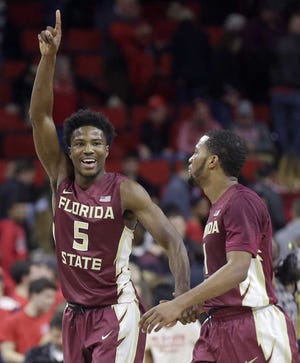 Florida State's Malik Beasley (5) and Devon Bookert celebrate following Florida State's 85-78 win over North Carolina State following an NCAA college basketball game in Raleigh, N.C., Wednesday, Jan. 13, 2016. (AP Photo/Gerry Broome)
