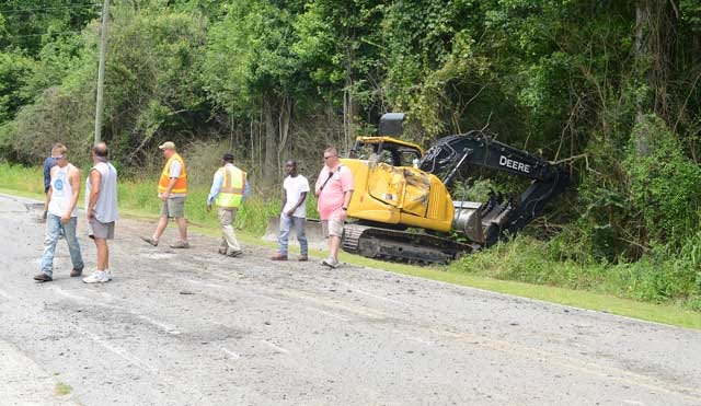 A damaged state Department of Transportation excavator sits Tuesday on the edge of Elijah Loftin Road after being thrown off a trailer when — according to the State Highway Patrol — the driver of the truck pulling the trailer moved left-of-center and over-corrected.