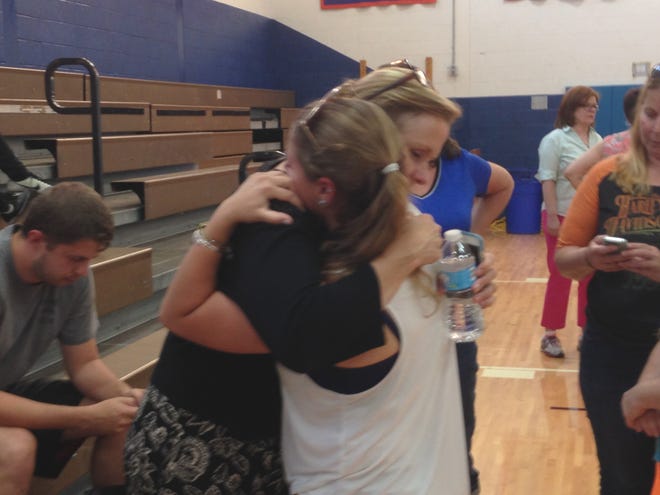 S.S. Seward's assistant principal Susan Moore gets a hug from senior Morgan Schultz. Schultz and about 30 other seniors lined the center of the gym floor at Seward to show their support for Moore. Faced with a contingency budget, the Florida school board voted to reduce Moore's salary, but saved her job. Richard J. Bayne/Times Herald-Record