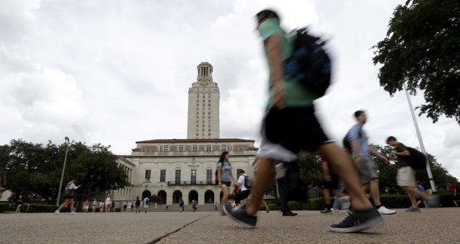 In this Sept. 27, 2012, file photoTexas students walk past the university's iconic tower, in Austin. In a 4-3 opinion, a court majority held that Texas had demonstrated its “narrowly tailored” policy of looking at race to fill one-quarter of its freshman classes was necessary because a strictly “nonracial approach” had failed to produce enough student diversity. (AP Photo/Eric Gay)