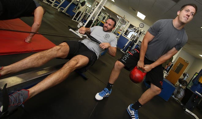Gastonia Police Officers Adam Wilson, left, and Andrew Pate work out in the Gastonia Police Department weight room Wednesday afternoon. The two men will be leaving for San Diego this weekend to take part in the U.S. Police and Fire Championships. PHOTO MIKE HENSDILL/THE GAZETTE