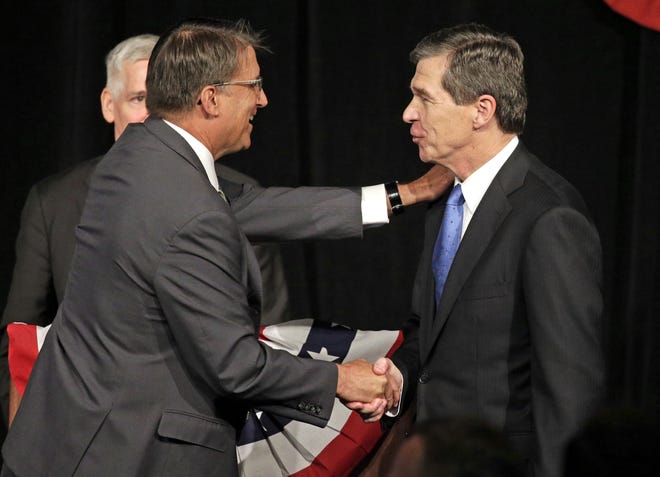 North Carolina Gov. Pat McCrory, left, shakes hands with challenger and North Carolina Attorney General Roy Cooper after a candidate forum Friday in Charlotte. AP Photo/Chuck Burton