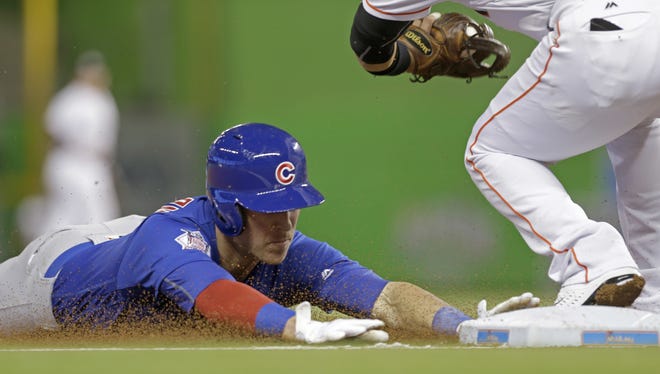 Chicago Cubs' Chris Coghlan, left, slides safely into third base on a triple against the Miami Marlins in the first inning of a baseball game, Friday, June 24, 2016, in Miami. (AP Photo/Alan Diaz)