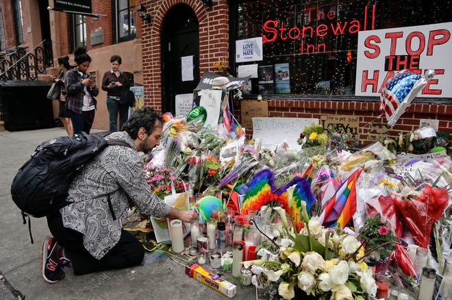 In this June 16 file photo, a man lights candles on a memorial outside the Stonewall Inn in New York in honor of victims of the Orlando shooting. President Barack Obama is designating the Stonewall Inn in New York a national monument, the first to honor gay rights.