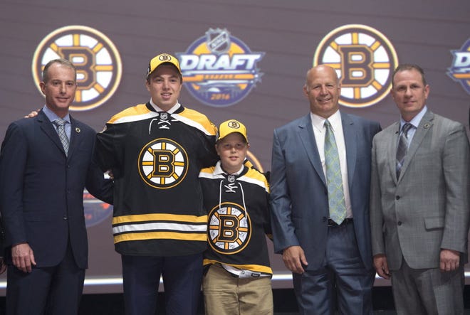 Charlie McAvoy, second from left, the Bruins' first-round draft pick, stands on stage with members of the Boston Bruins management team, including owner Charlie Jacobs, left, and coach Claude Julien, second from right, at the NHL Draft in Buffalo on Friday.