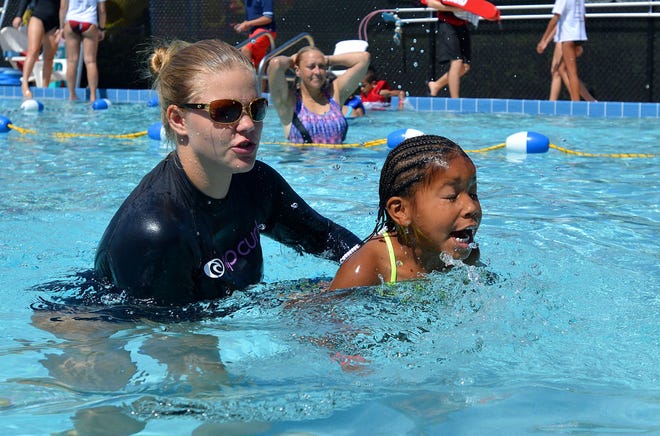 Instructor Chloe Barber helps a girl make her way back to the edge of the pool during the World's Largest Swimming Lesson at the Golden Triangle YMCA on Frida in Tavares.
