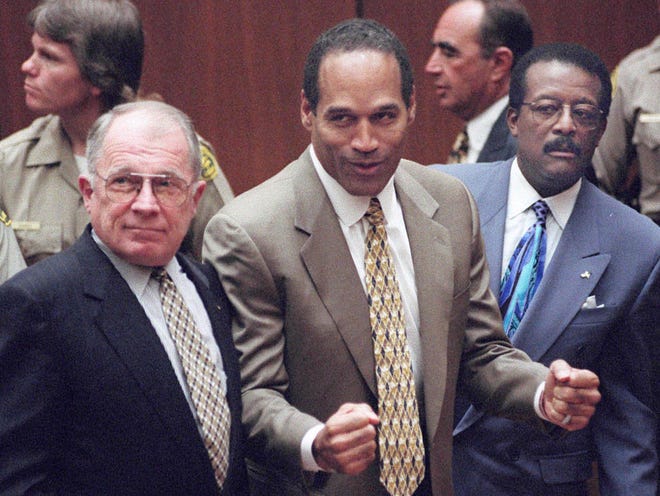 O.J. Simpson reacts as he is found not guilty of murdering his ex-wife, Nicole Brown Simpson, and her friend Ron Goldman at the Criminal Courts Building in Los Angeles Oct. 3, 1995. At left is defense lawyer F. Lee Bailey and at right, defense attorney Johnnie Cochran Jr. Defense attorney Robert Shapiro is in profile behind them.