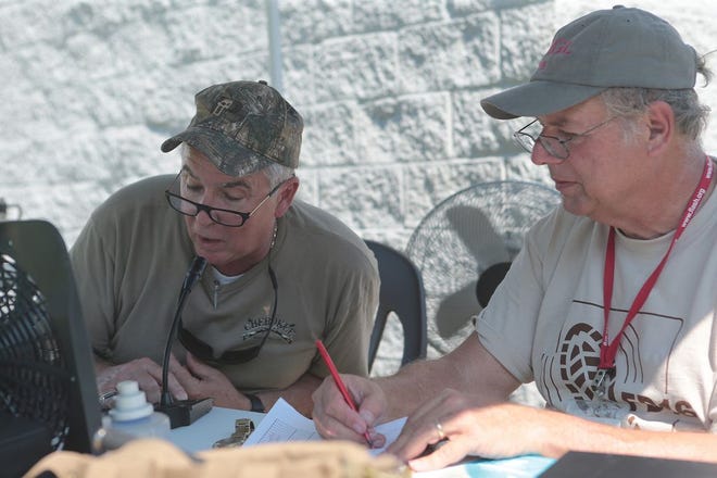 Doug Helms, left, and Greg Lane communicate with operators all around the country during a national Amateur Radio Field Day exercise Saturday at the Bay County Emergency Operations Center in Panama City.