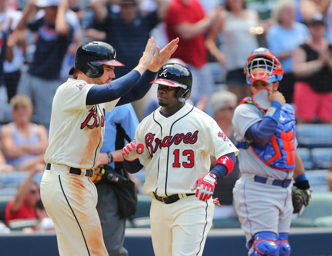 Atlanta Braves' Adonis Garcia (13) celebrates with teammate Freddie Freeman after hitting a three-run home run in the eighth inning of a baseball game against the New York Mets, Sunday, June 26, 2016, in Atlanta. (AP Photo/John Bazemore)
