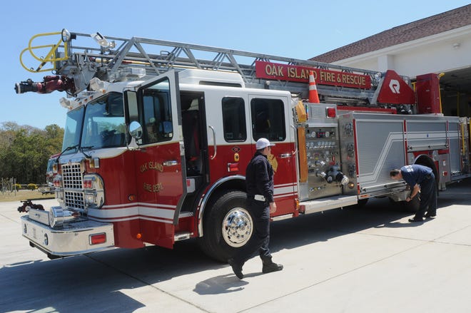 Oak Island Fire Department firefighters demonstrate the capabilities of a ladder truck in 2013. StarNews file photo.