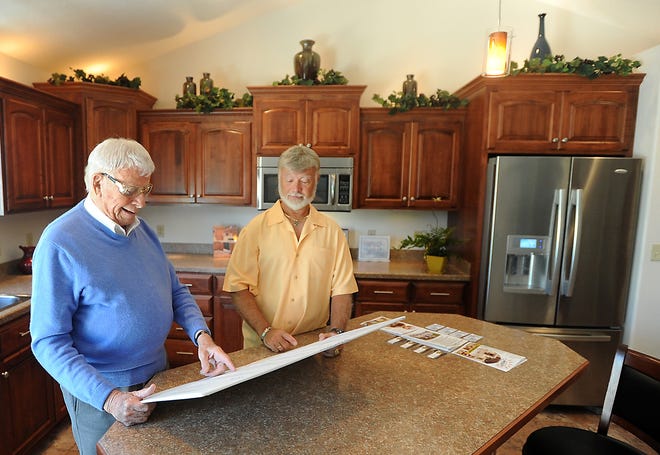 Times-Reporter File/Jim Cummings

In this 2011 photo, Dale "Wally" Waldenmyer and his son, Brad, of Waldenmyer Builders look at plans in the model home at the development on Chelsea Drive in Dover.