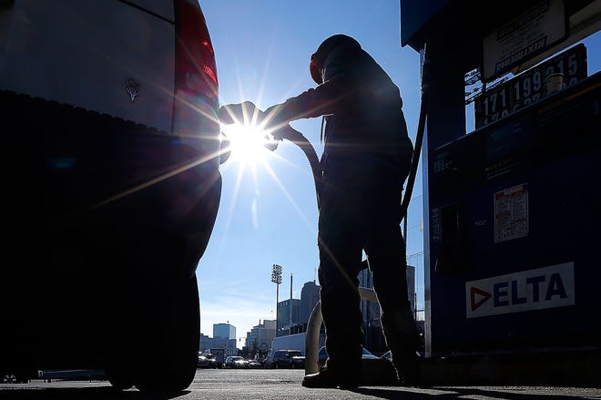(File) In this January 2015 photo, Sonu Singh works at a Delta gas station in downtown Newark. The state's ailing Transportation Trust Fund is the state's chief mechanism for financing highway and bridge repairs and mass transit improvements, but is overburdened with debt and in need of new revenues.