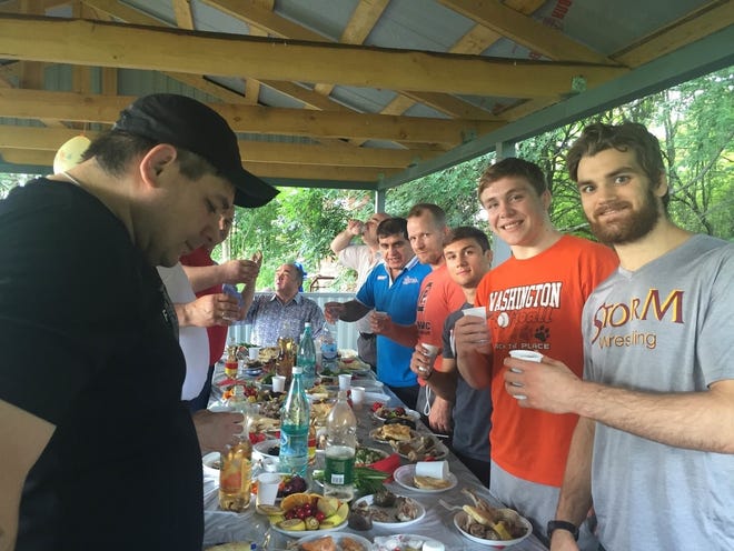 PHOTO COURTESY BRYAN MEDLIN

Washington wrestlers Colin Carr, right, Jacob Warner, second from right, Dack Punke, third, and coach Bryan Medlin, fourth, eat dinner while in a recent trip to Russia.