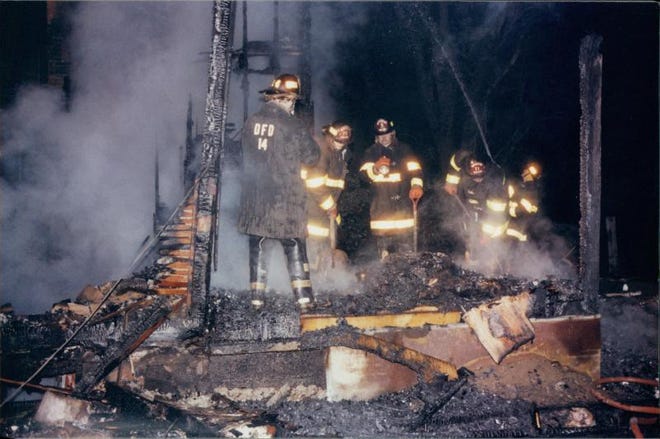 Deerfield Township volunteer firefighters investigate a house fire that killed two teens in 1982. Authorities from Lenawee and Monroe counties are investigating the crime again.