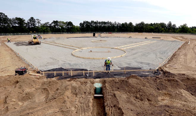 In this photo taken Wednesday, April 20, 2016, contractors install a baseball field at Fort Bragg, N.C. The race is on to build a big-league baseball field from scratch. The Atlanta Braves and Miami Marlins will play a salute-the-troops game at this vast U.S. Army post the night before Independence Day. (AP Photo/Gerry Broome)