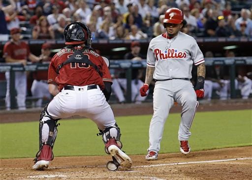 Arizona Diamondbacks' Chris Herrmann, left, waits to tag out Philadelphia Phillies' Freddy Galvis as he tries to score on a double by teammate Cesar Hernandez during the fourth inning of a baseball game Wednesday, June 29, 2016, in Phoenix. (AP Photo/Ross D. Franklin)