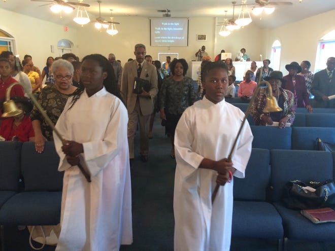 Two young members of Bartley Temple United Methodist Church serve as acolytes Sunday during the morning worship service. Behind them are Elder Rev. Mary L. Mitchell, right, pastor of the church, and the Rev. L. Milford Griner, now associate pastor of the church. Photos by Cleveland Tinker/Special to the Guardian