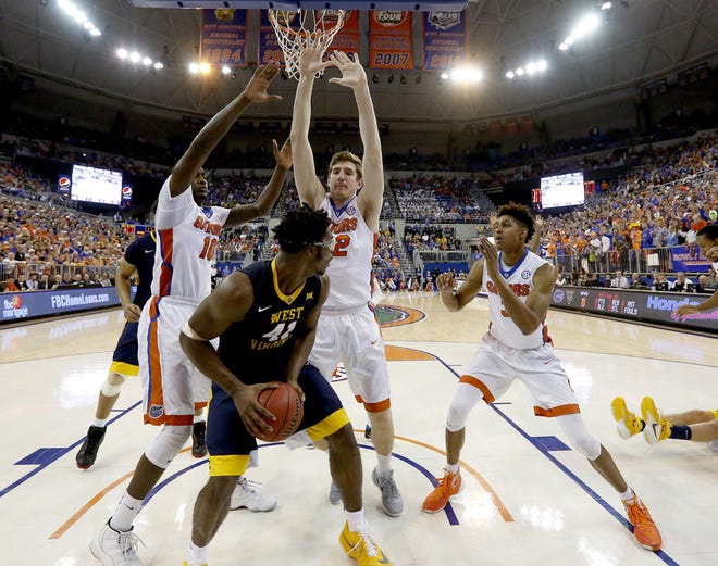 Florida forwards Dorian Finney-Smith, Schuyler Rimmer (32) and Devin Robinson trap West Virginia forward Devin Williams under the basket during the first half of their Jan. 30 game at the O'Connell Center. Florida defeated then-No. 9 West Virginia 88-71, one of the few quality wins for the Gators last season. (Matt Stamey/The Gainesville Sun)