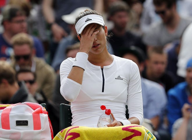 French Open champion Garbine Muguruza sits on a chair during a break in her loss to Jana Cepelova in the second round at Wimbledon on Thursday.