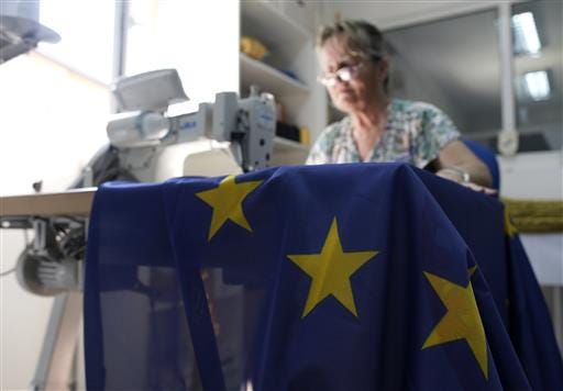A seamstress sews an EU flag in a workshop in Belgrade, Serbia, Wednesday, June 29, 2016. Serbia, Montenegro, Macedonia, Bosnia, Kosovo and Albania, all at different stages in joining the EU, have declared that the British exit in a referendum last week will not diminish their membership efforts. (AP Photo/Darko Vojinovic)
