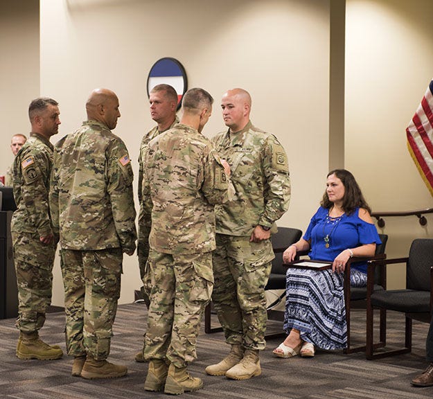 Maj. Gen. Richard Clarke, commanding general of the 82nd Airborne Division, pins Spc. Rogers with the Soldier's Medal at the XVIII Noncommissioned Officer Academy, June 24.