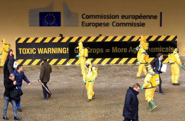 Activists of environmental group Greenpeace wear masks and protective clothing while protesting outside the European Commission headquarters in Brussels November 7, 2012. REUTERS/Yves Herman