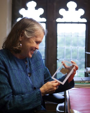 In this photo released in September 2012 by Harvard University, divinity professor Karen L. King holds a fourth century fragment of papyrus that she said was the only existing ancient text that quotes Jesus explicitly referring to having a wife. Based on new evidence, King told the Associated Press recently she now thinks it is likely a fake. (AP FILE)