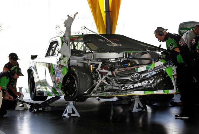 Photos by John Raoux Associated Press Crew members work on Kyle Busch's car after he wrecked during practice Friday at Daytona International Speedway.