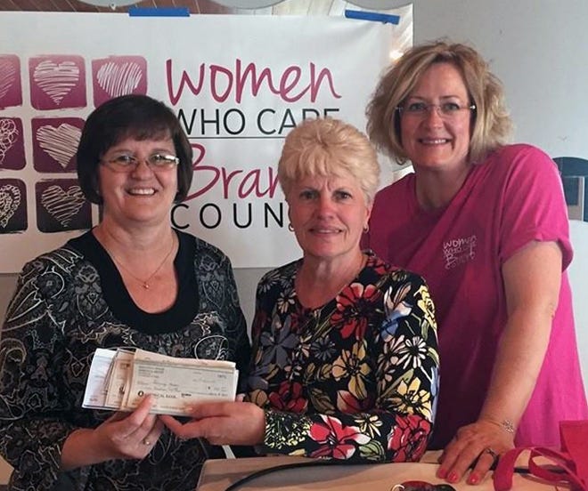 Sandy Sexton accepts a donation on behalf of Tommy's House from Women Who Care steering committee members Marie Wilber and Diana Butler. Courtesy photo