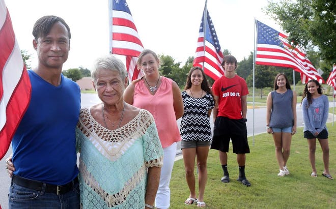 Jason Robertson, who was orphaned during the Vietnam War and later adopted by an American family, is seen with veterans rights advocate Karen Biddle in Niceville. At the rear is Robertson's family: wife Debbie, daughter Melanie, son Nathan, and daughters Meredith and Naomi.