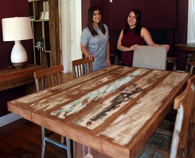 Laura and Simone Pereira show a dining room table made from reclaimed wood at their shop, Elburne, in Dennis. Steve Haines/Cape Cod Times