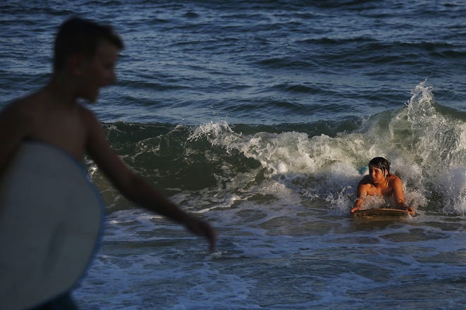 A young boy rides a wave on a body board in Orange Beach. (AP Photo/Brynn Anderson)