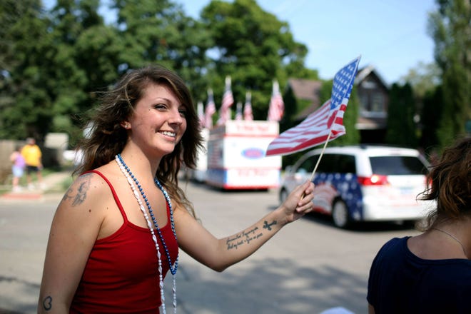 Laura Holmes waves an American flag during West Burlington’s Fourth of July parade in 2012.